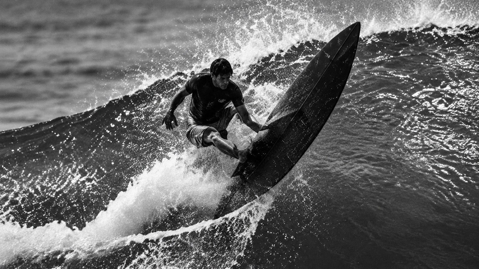 Surfer riding a wave, black and white